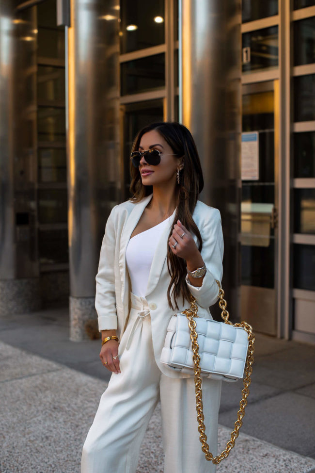 mia mia mine wearing a white blazer and white one shoulder top from express