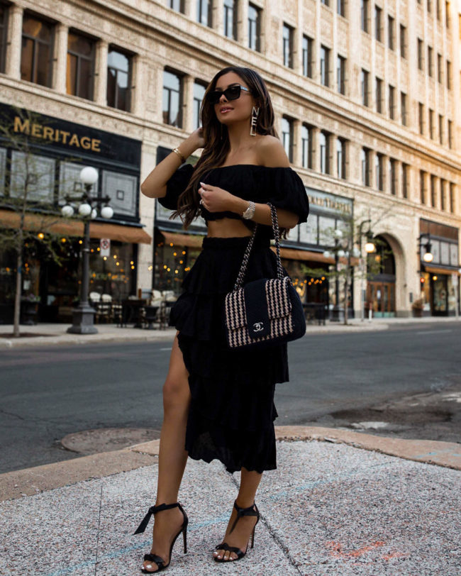 fashion blogger mia mia mine wearing a black crop top and ruffle skirt from revolve