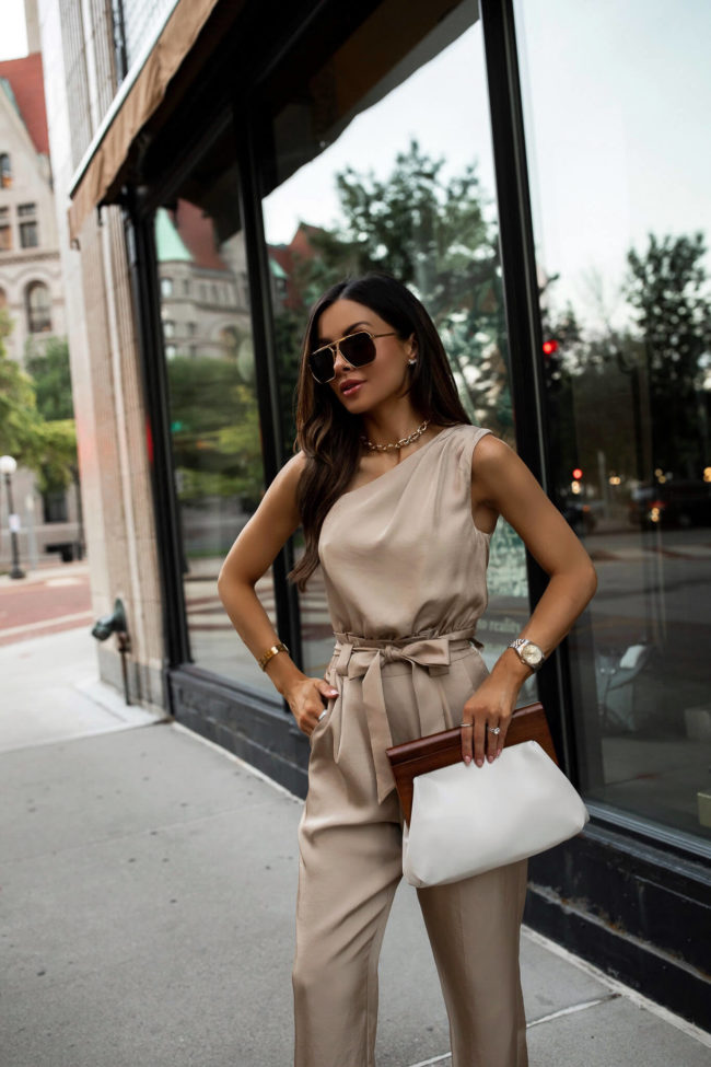 fashion blogger mia mia mine wearing a one shoulder jumpsuit from express