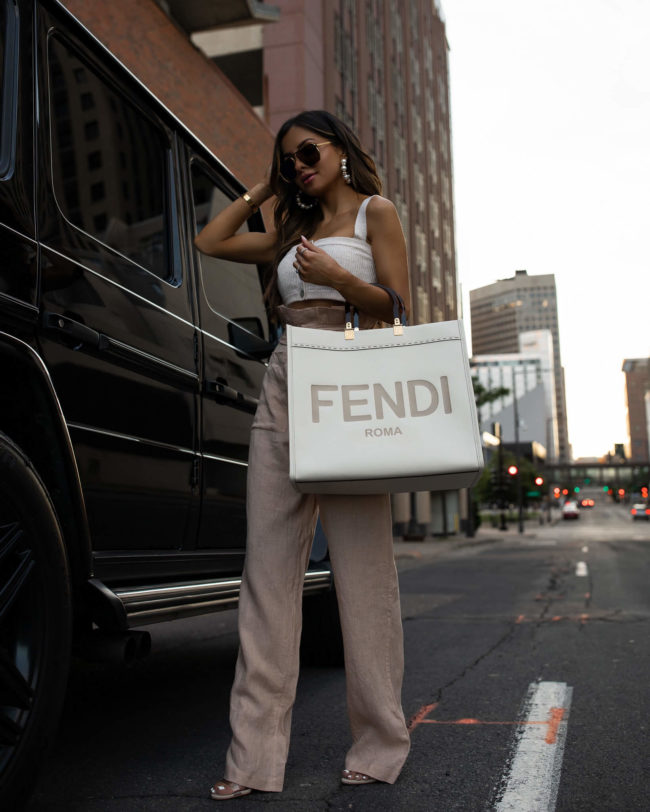 mia mia mine wearing revolve linen pants and a fendi sunshine tote