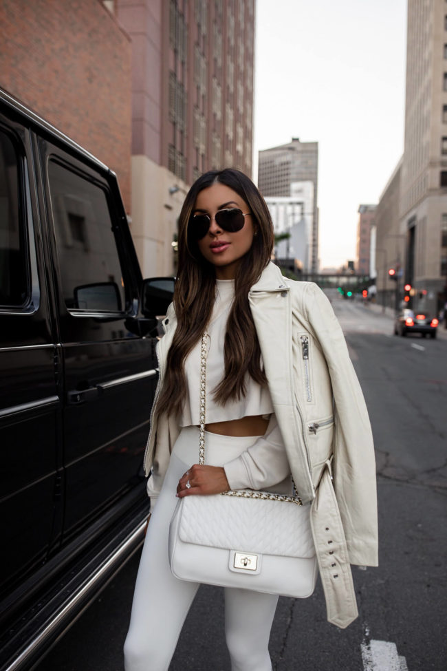 fashion blogger mia mia mine wearing an all white workout outfit from saks off 5th