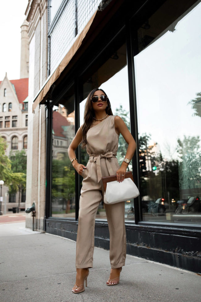mia mia mine wearing a tan one shoulder jumpsuit from express