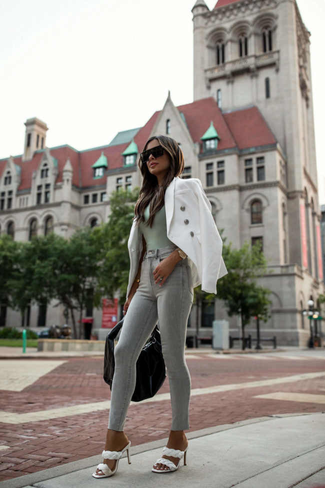brunette fashion blogger wearing gray denim and a white blazer from express