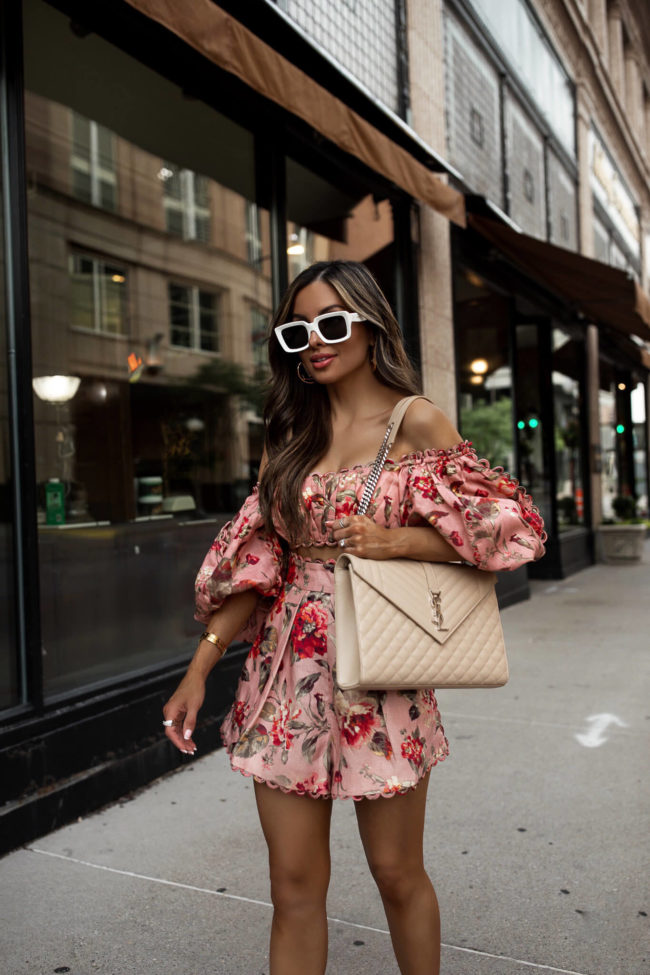mia mia mine wearing a saint laurent envelope bag and a zimmermann floral outfit for summer