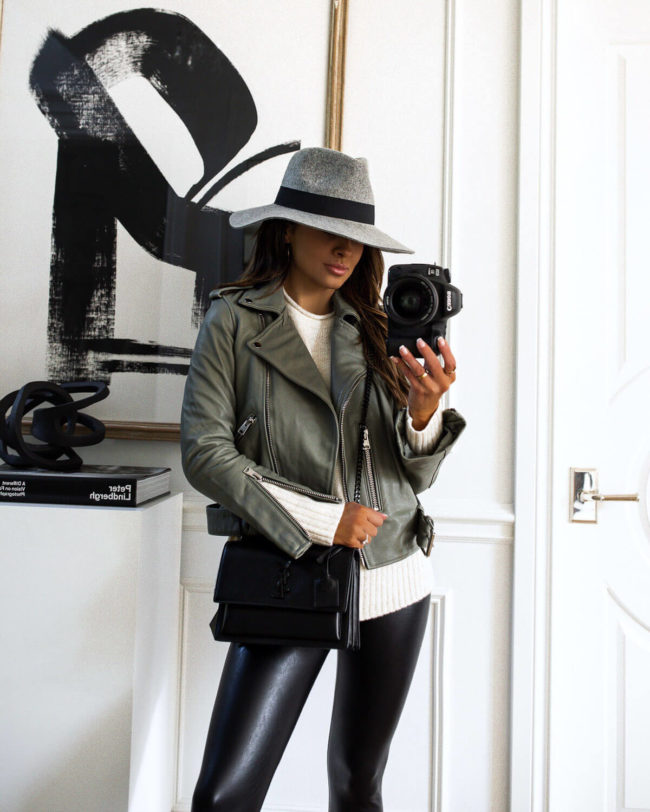brunette fashion blogger wearing a gray allsaints leather jacket and commando leggings