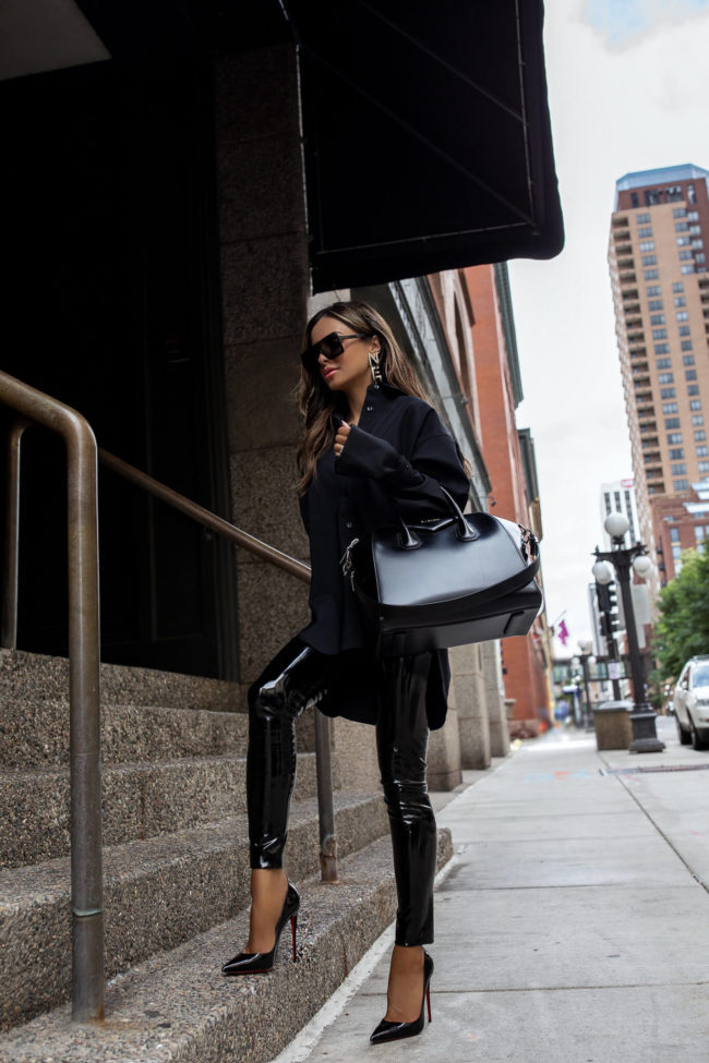 fashion blogger wearing patent leather pants and an oversized button up top from nordstrom