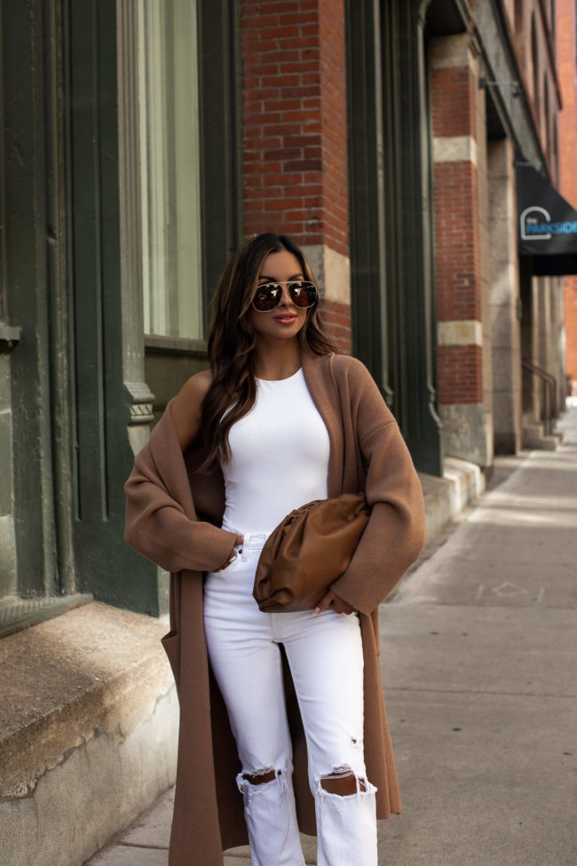 fashion blogger mia mia mine wearing a camel coat and white outfit