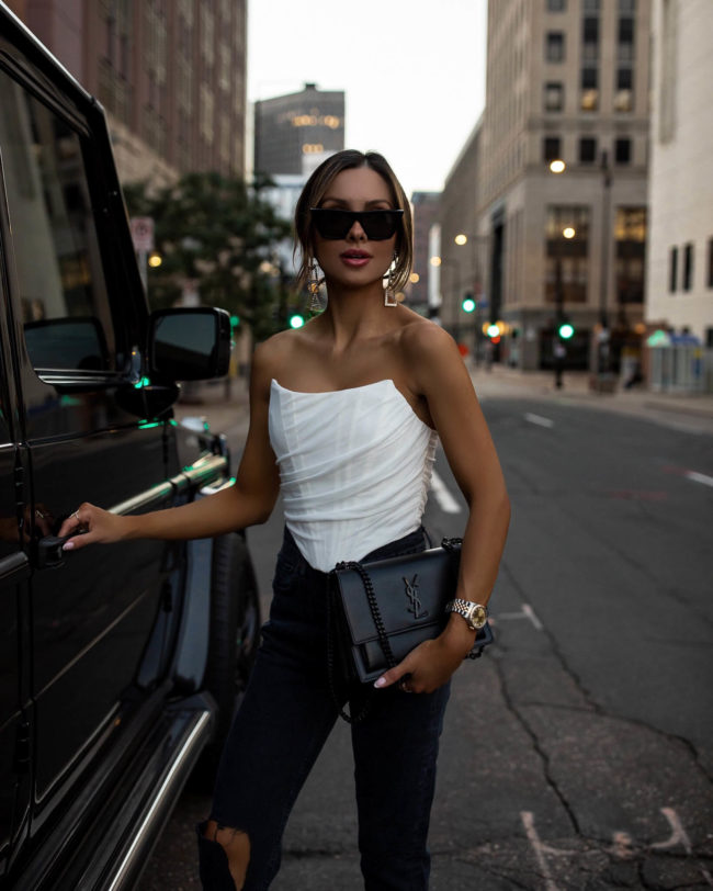 fashion blogger wearing a white corset top and agole denim