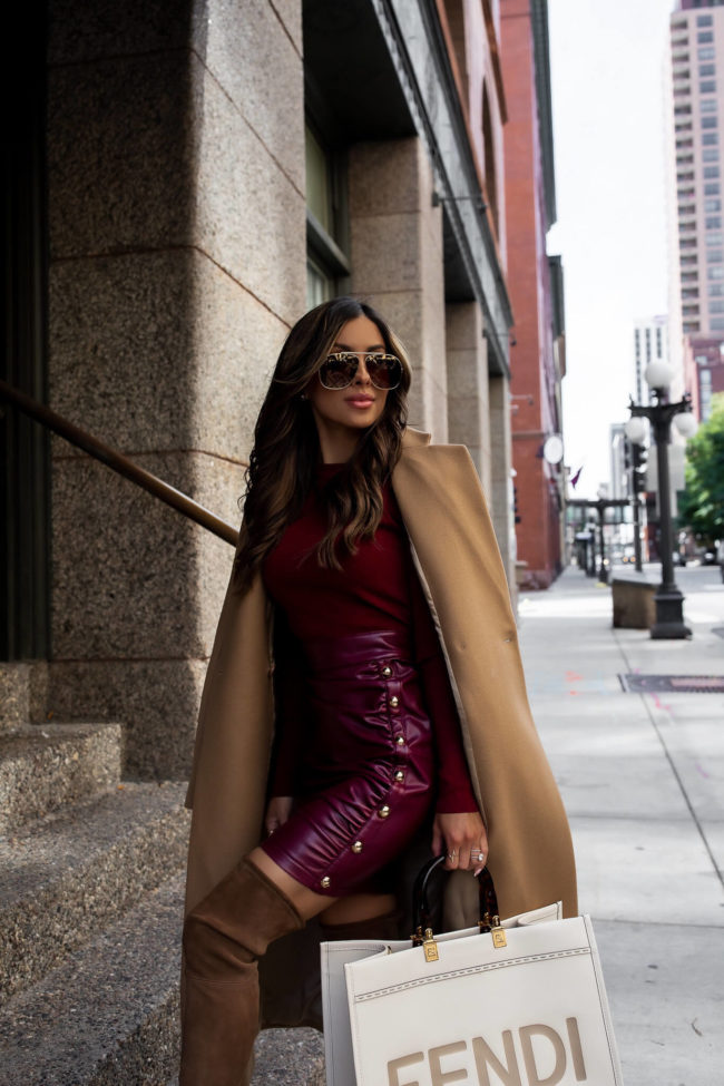 fashion blogger wearing a burgundy dress and camel coat