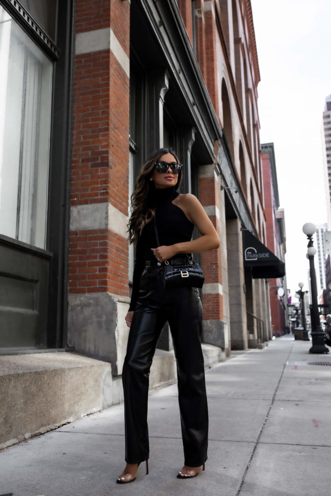 fashion blogger wearing a one shoulder top and leather pants from bloomingdales