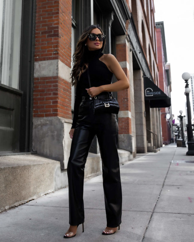 fashion blogger wearing a one shoulder top and leather pants from bloomingdales