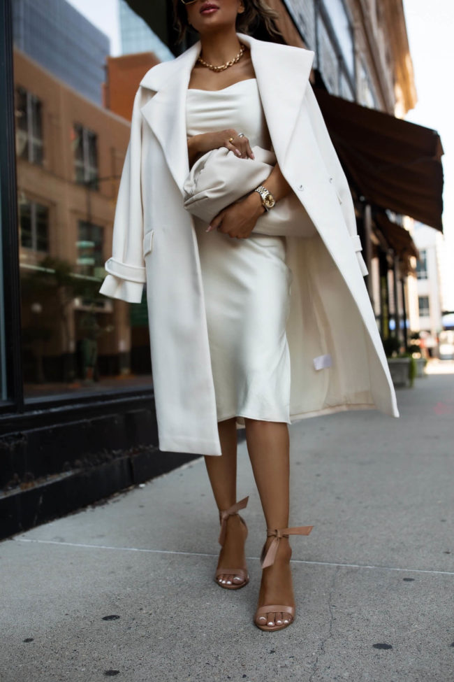 fashion blogger wearing nude bow heels with a white dress