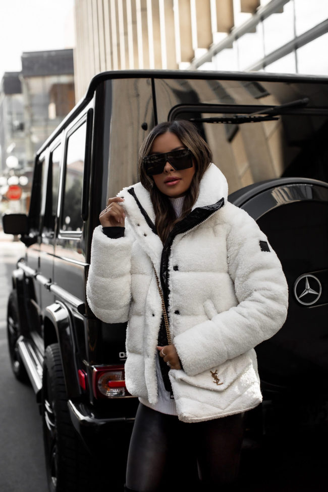 fashion blogger wearing a white sherpa puffer jacket and spanx faux leather leggings from saks fifth avenue
