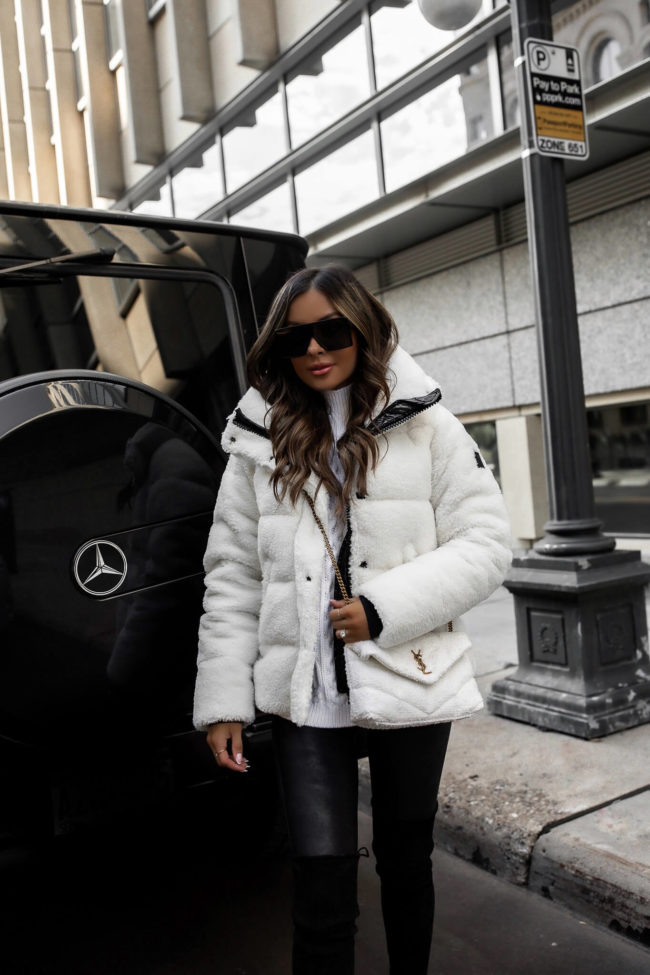 fashion blogger wearing a white puffer jacket and faux leather leggings with a ysl toy puffer white bag