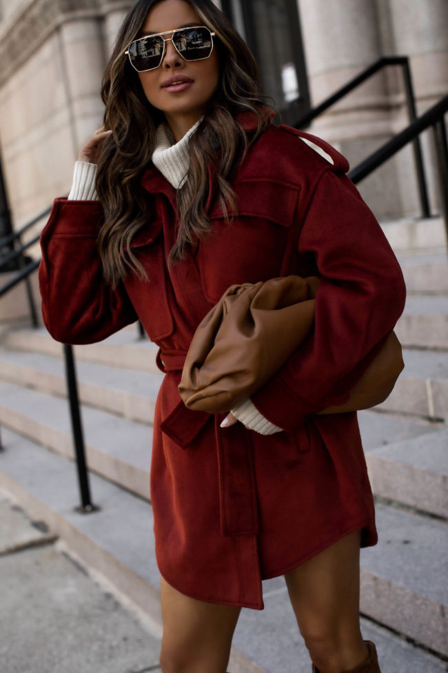 fashion blogger wearing a burgundy shacket and sweater dress