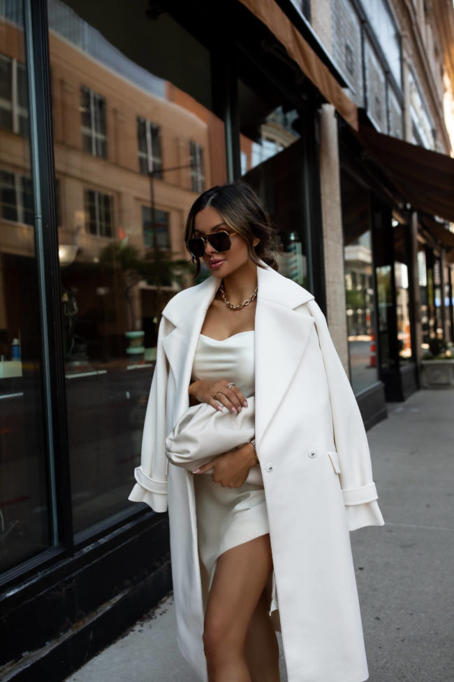 fashion blogger wearing a white silk dress and white wool coat 