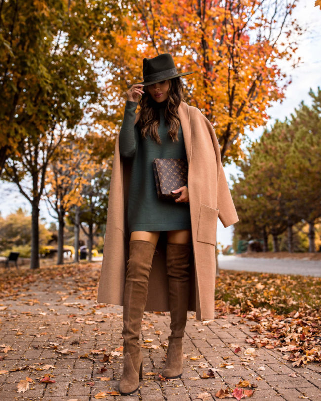 fashion blogger wearing a camel coat and over the knee boots