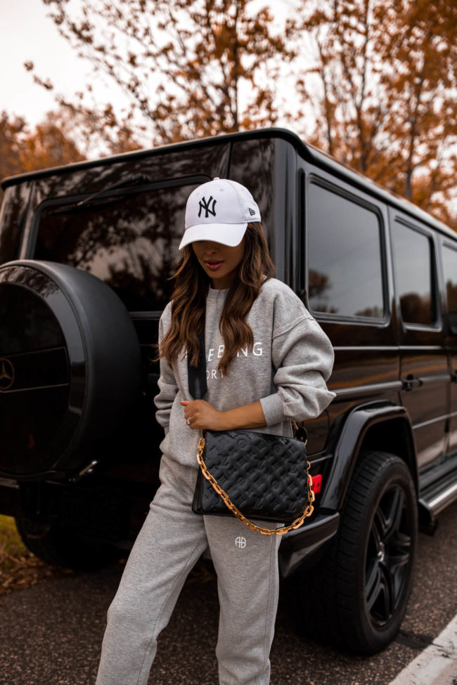 fashion blogger wearing an anine bing sweatsuit and a louis vuitton coussin bag