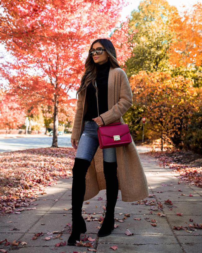 fashion blogger wearing over the knee boots and a camel duster cardigan