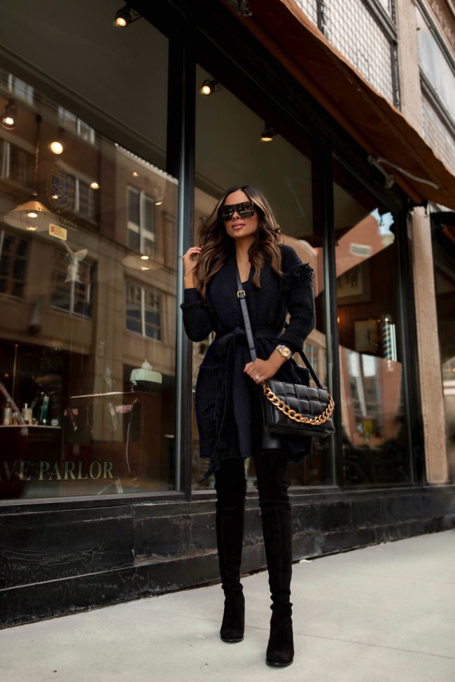 fashion blogger mia mia mine wearing a black fringe cardigan and black faux leather pants from walmart