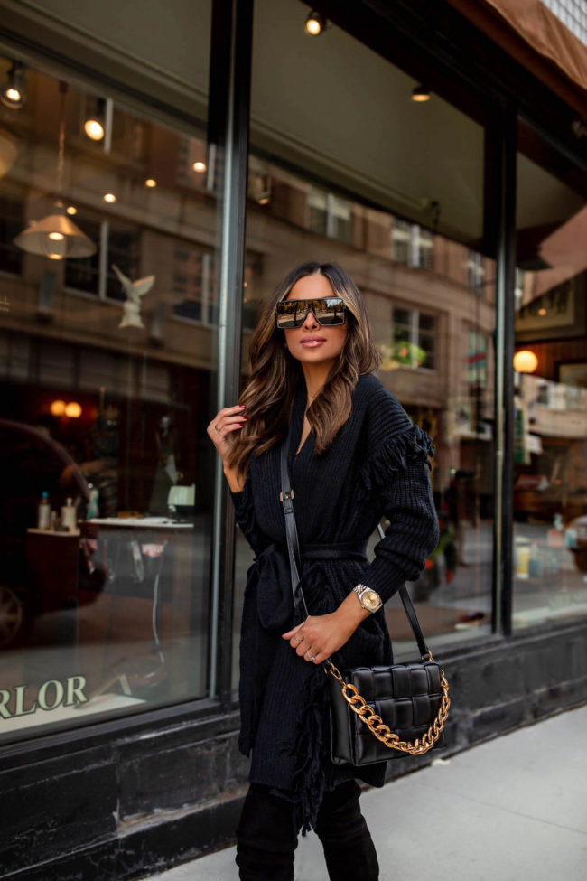 fashion blogger mia mia mine wearing a black fringe cardigan and faux leather pants