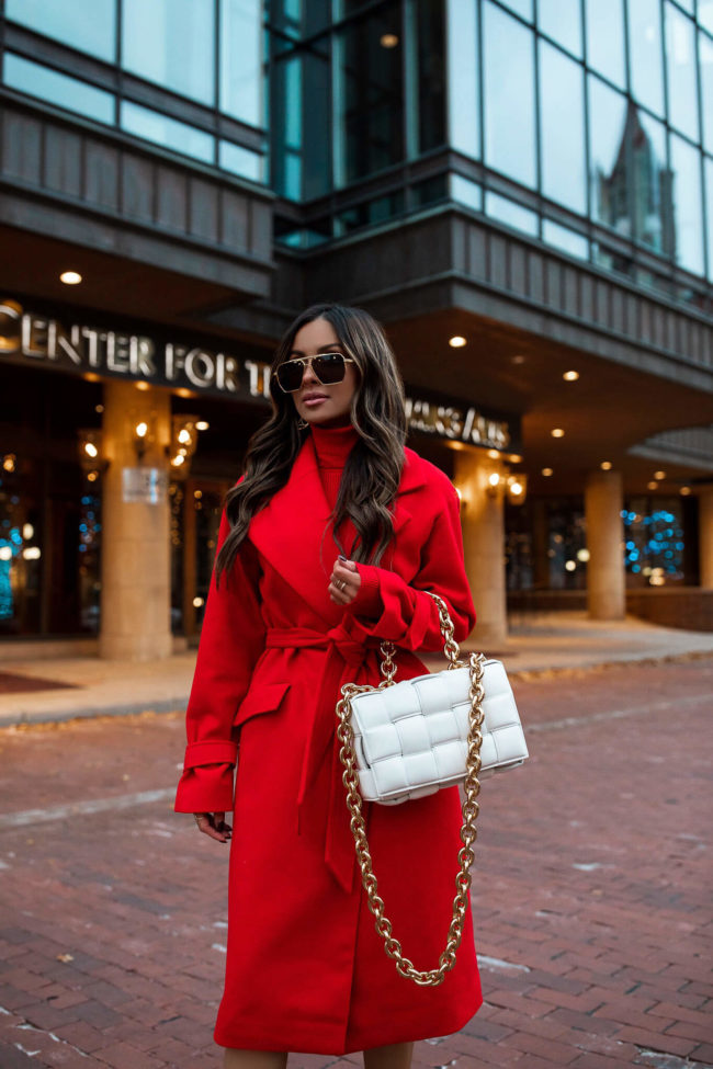 brunette fashion blogger wearing a red coat and dress for the holidays