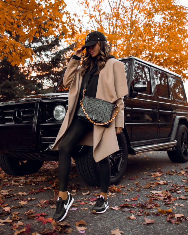 mia mia mine wearing a camel coat with the louis vuitton coussin pm bag