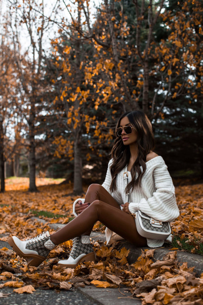 fashion blogger mia mia mine wearing a free people sweater with brown leggings and gucci lug sole boots