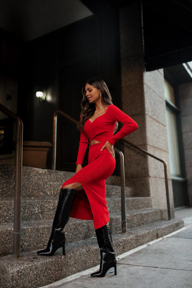 fashion blogger mia mia mine wearing a red matching knit set with black knee high boots