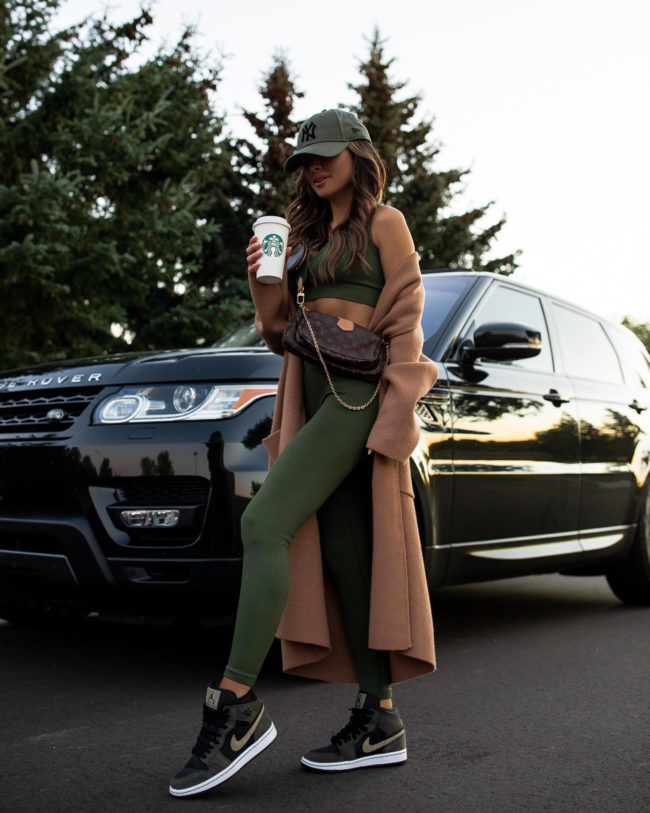 fashion blogger mia mia mine wearing nike air jordan sneakers and a green workout set