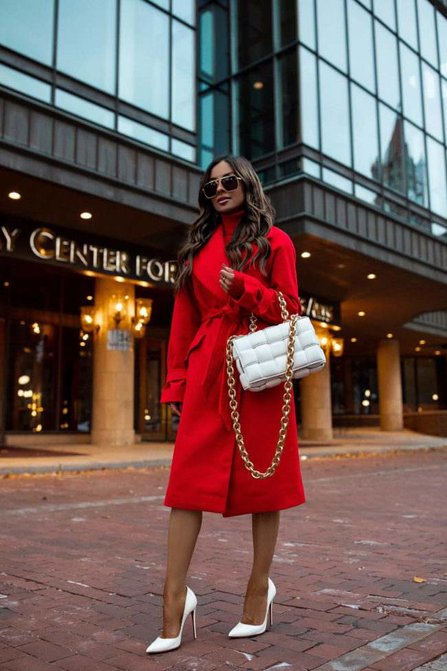 fashion blogger mia mia mine wearing a red coat and red sweater dress from express