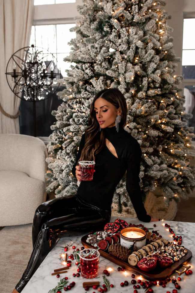 brunettte fashion blogger wearing an all black outfit with holiday drinks from walmart