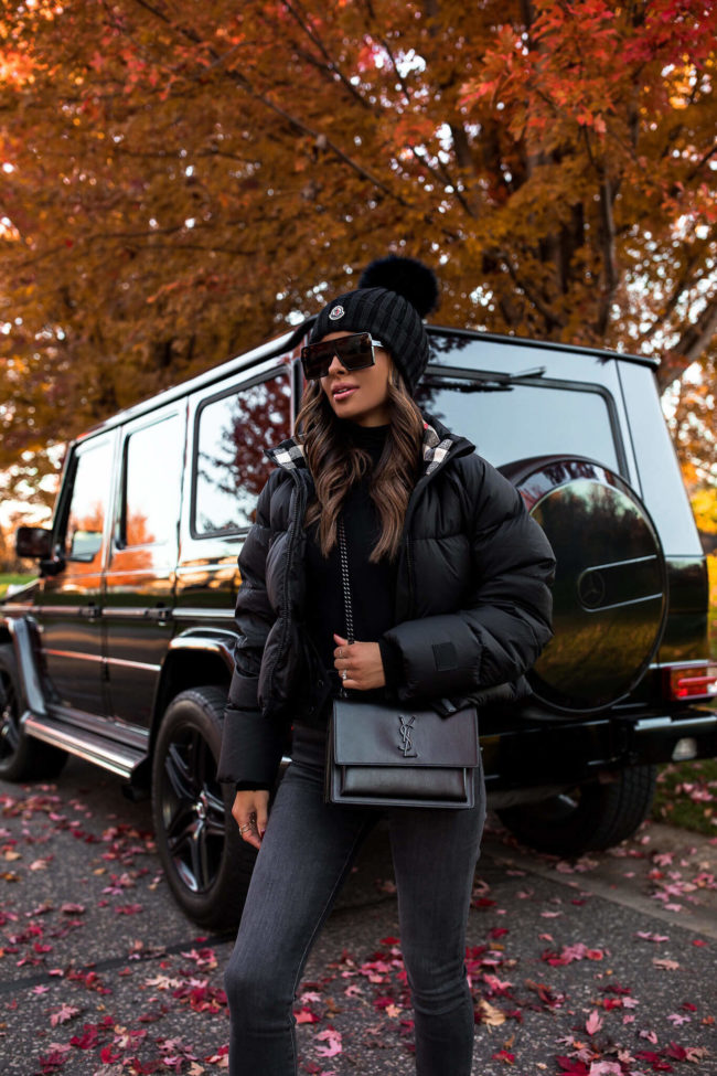 fashion blogger mia mia mine wearing a black burberry puffer jacket and a saint laurent sunset bag