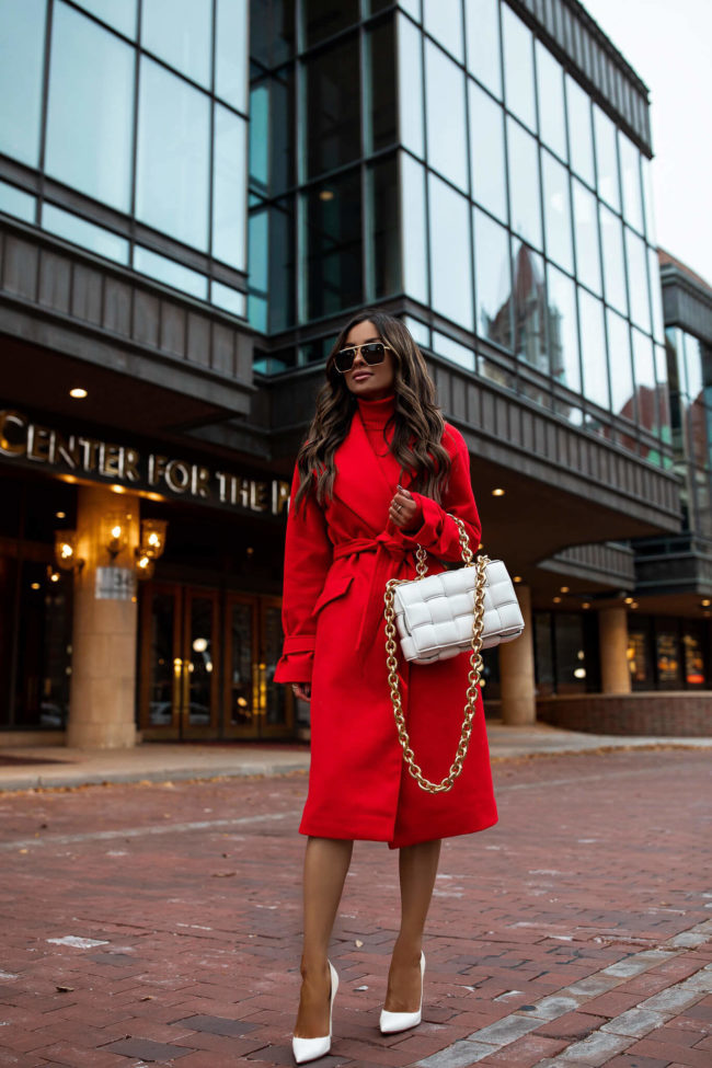 fashion blogger mia mia mine wearing a red coat and red sweater dress from express