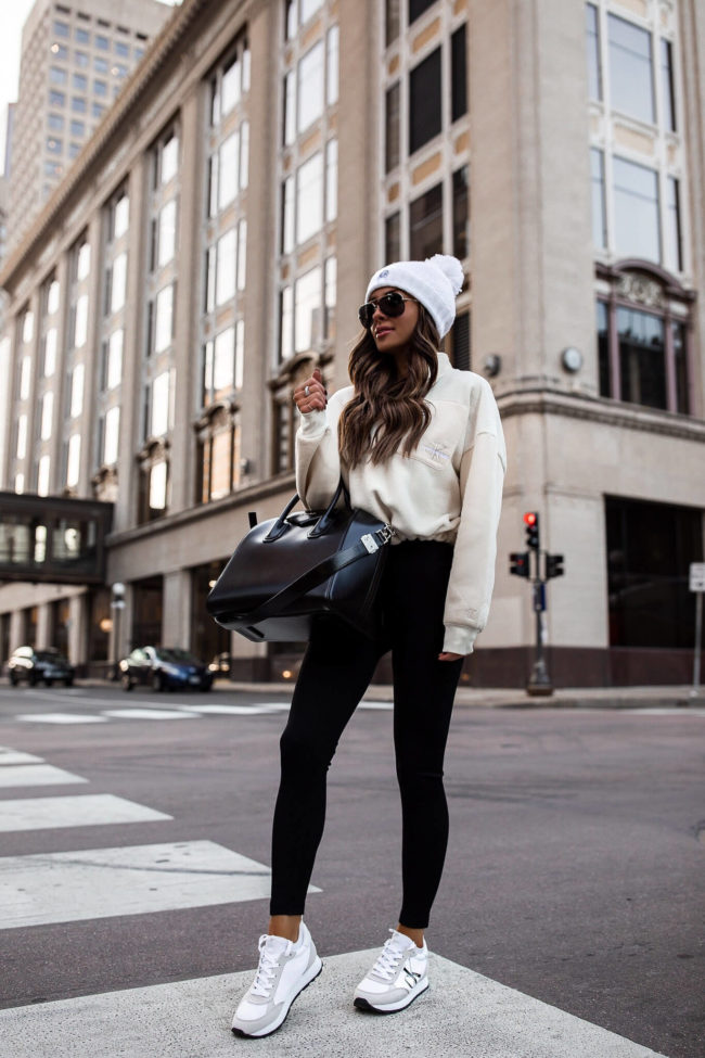 fashion blogger wearing calvin klein black leggings and a sneakers