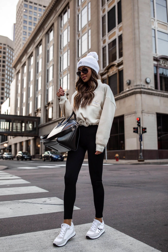 fashion blogger wearing calvin klein black leggings and a sneakers