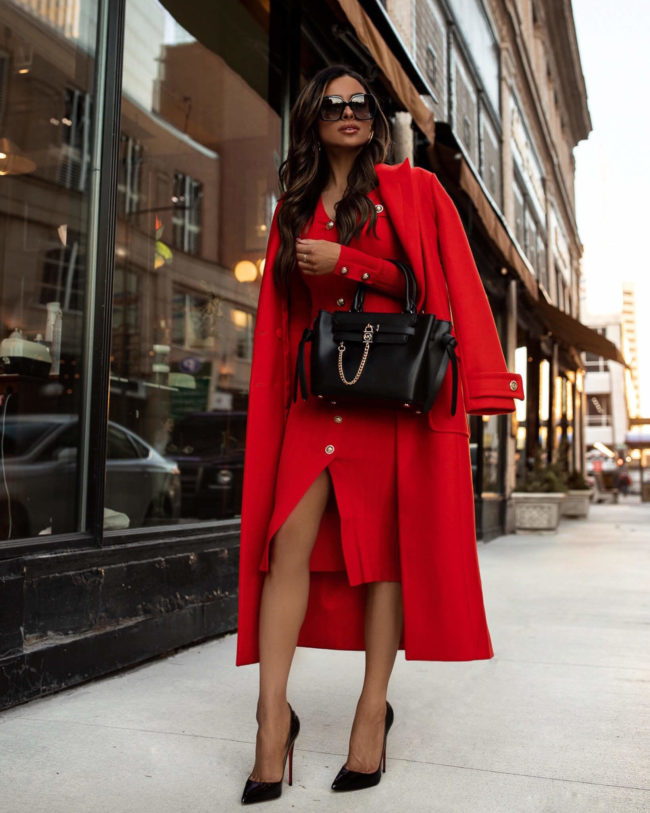 fashion blogger wearing a red knit dress and red coat from karen millen