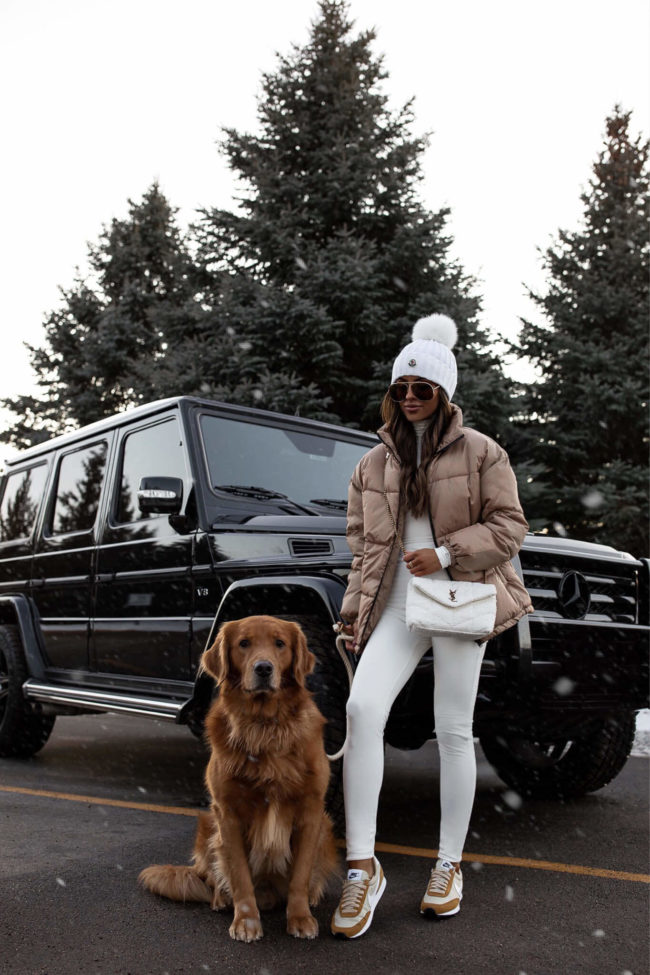 fashion blogger with golden retriever wearing a white outfit and a puffer jacket and nike daybreak sneakers
