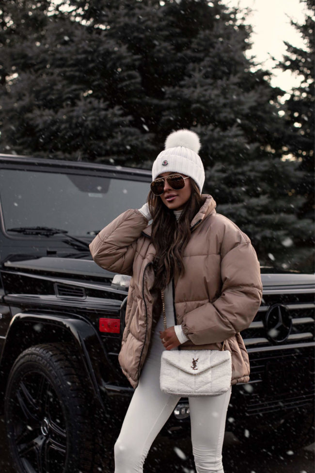 fashion blogger mia mia mine wearing a puffer jacket and a white beanie