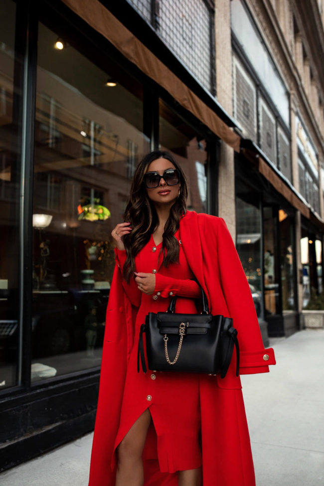 fashion blogger wearing a red knit dress and a michael kors bag