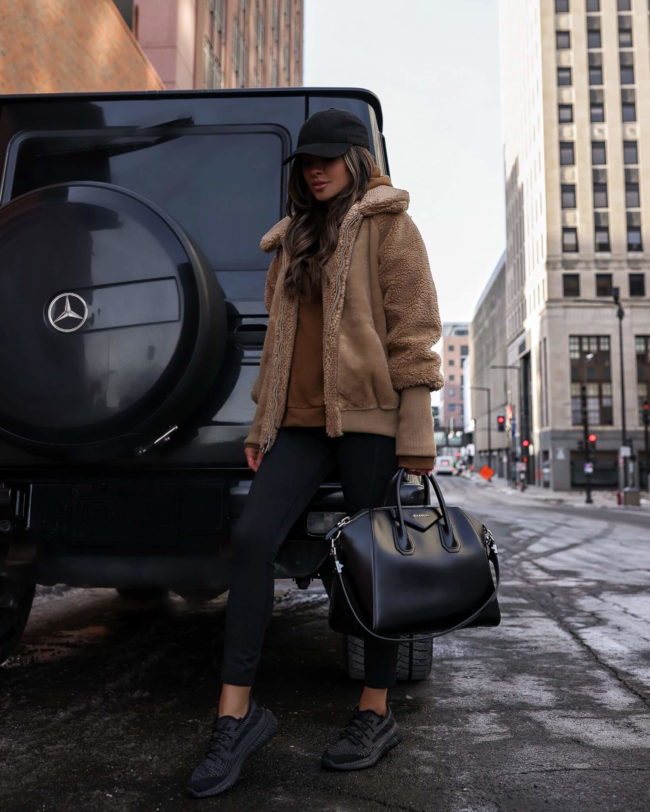 fashion blogger mia mia mine wearing a teddy bear jacket and black sneakers from walmart