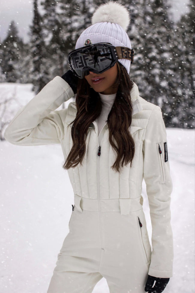 fashion blogger mia mia mine wearing fendi ski goggles and a white perfect moment ski suit