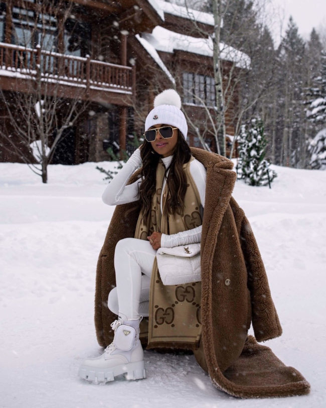 fashion blogger mia mia mine wearing a gucci scarf and white prada boots in jackson hole