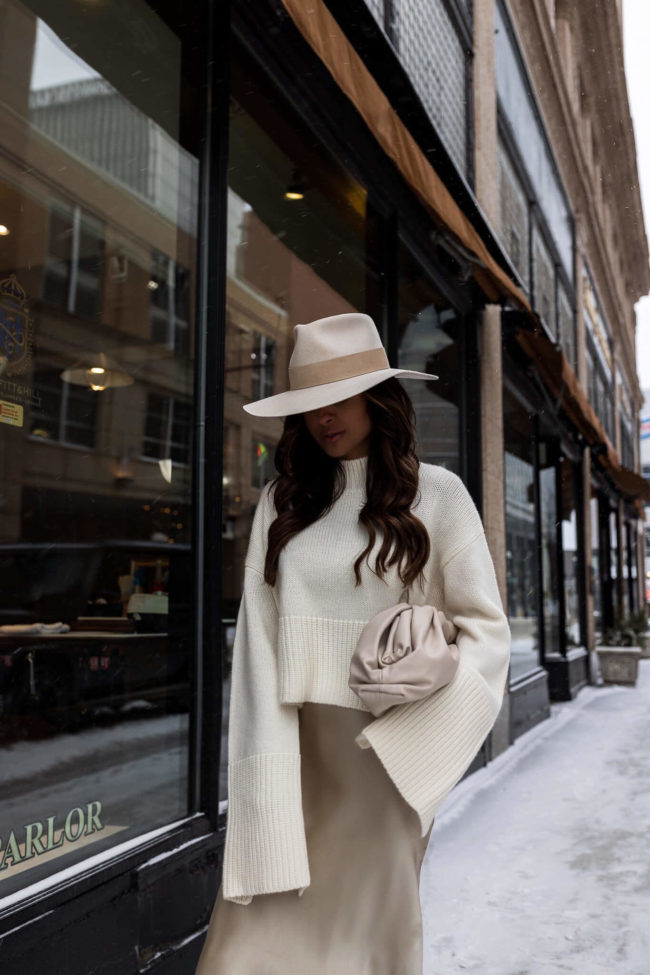 fashion blogger mia mia mine wearing a white slit sleeve sweater from silk maison