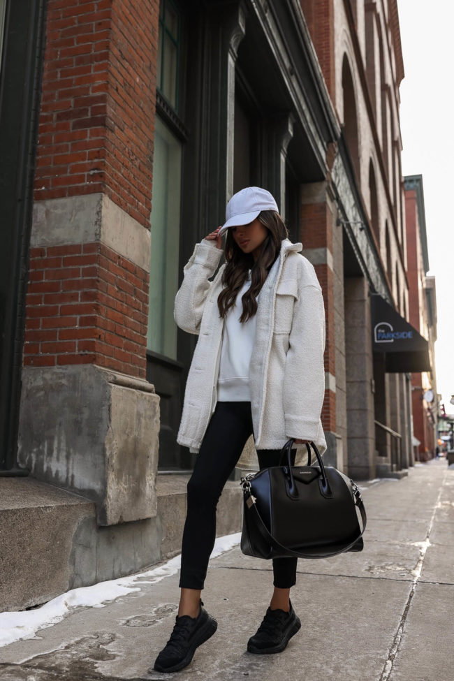 fashion blogger mia mia mine wearing a white shacket and black leggings from walmart