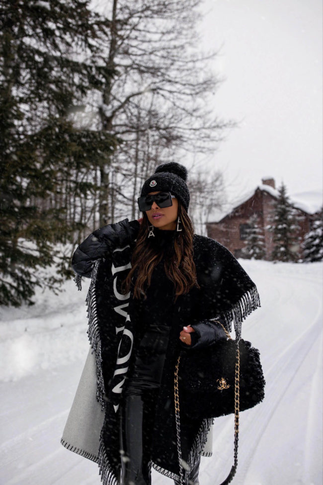 fashion blogger wearing a moncler poncho and chanel shearling bag