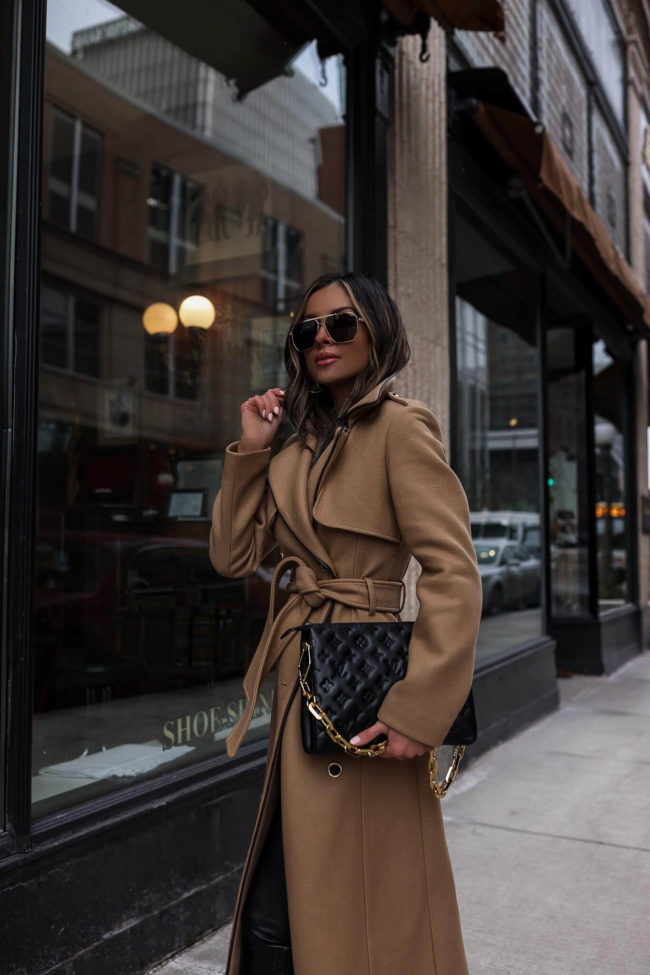 fashion blogger wearing a camel blazer and lv black coussin bag