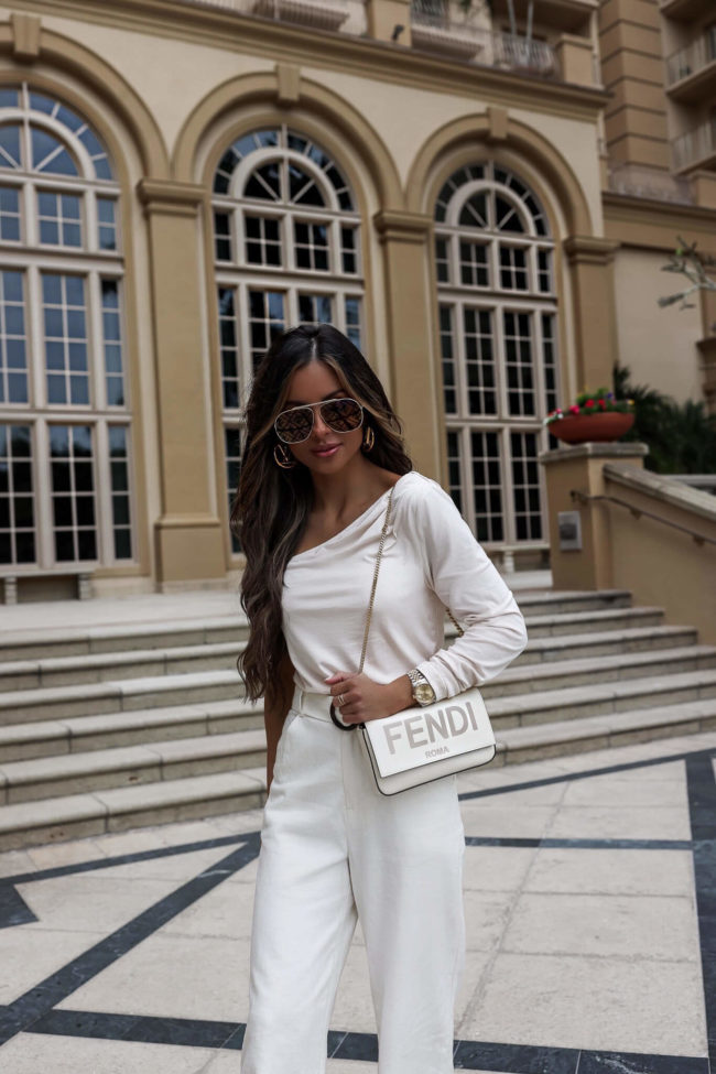 fashion blogger wearing fendi sunglasses and a white fendi wallet on chain