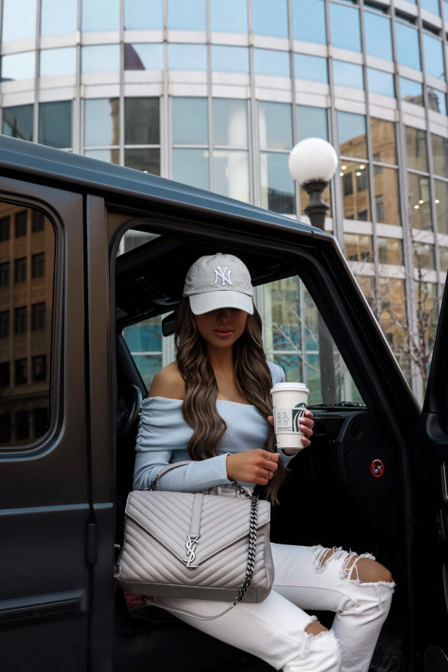 fashion blogger wearing white denim and a ny yankees cap