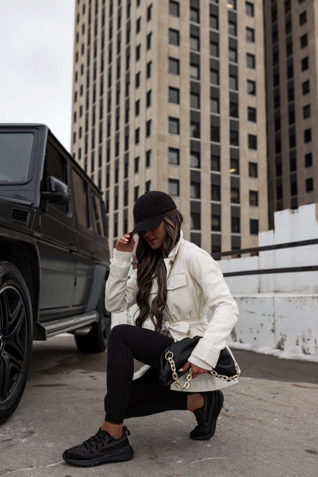 fashion blogger mia mia mine wearing a white utility jacket and black leggings from walmart